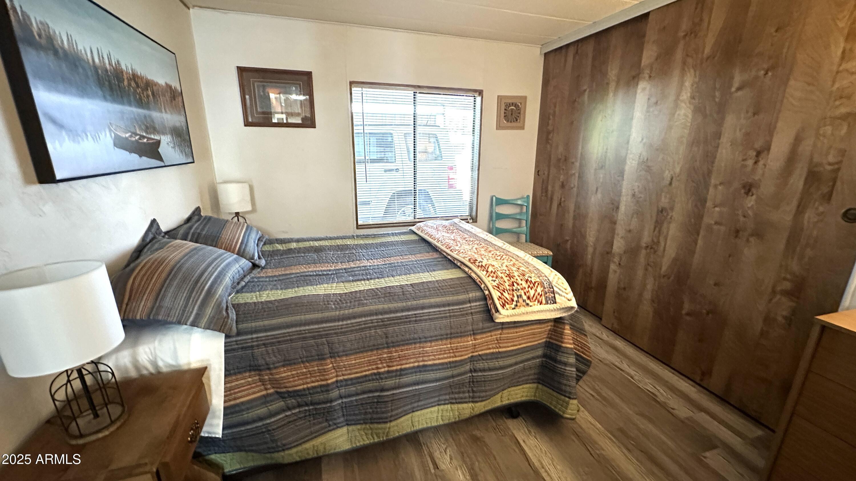 834 South Meridian Road, Unit 124 Apache Junction, AZ 85120 - Photo 25 of 28 a bedroom with a bed and wooden floor