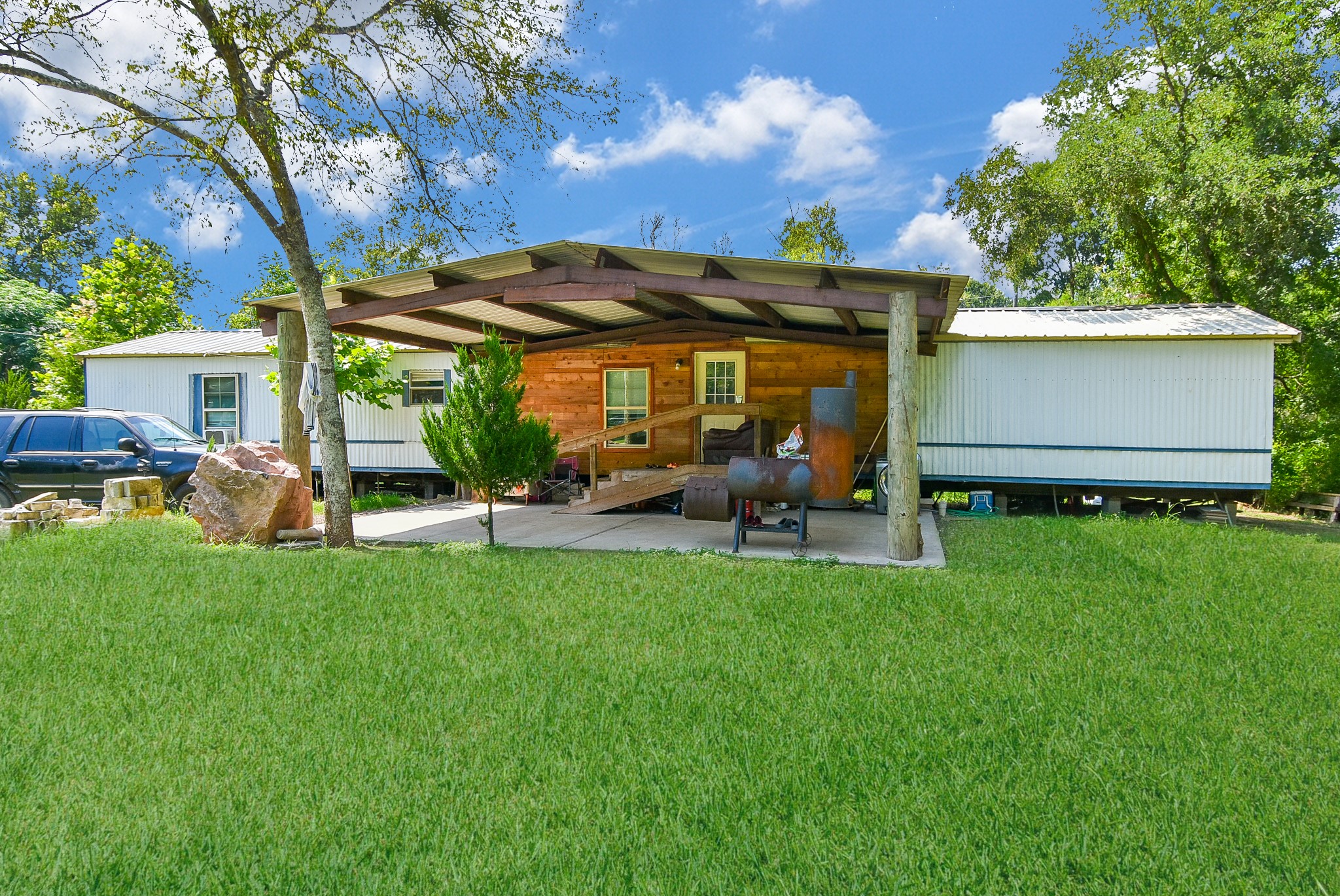 39551 Donigan Road Brookshire, TX 77423 - Photo 16 of 37 Rear view of property featuring a yard, a patio, and a metal roof