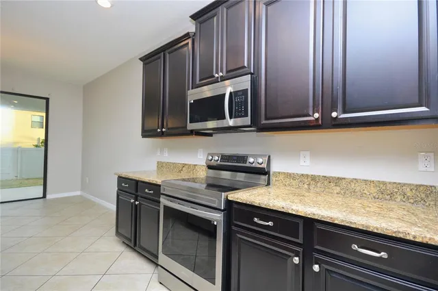 a kitchen with granite countertop cabinets stainless steel appliances and a counter space