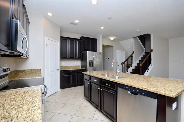 a kitchen with stainless steel appliances granite countertop a sink stove and refrigerator