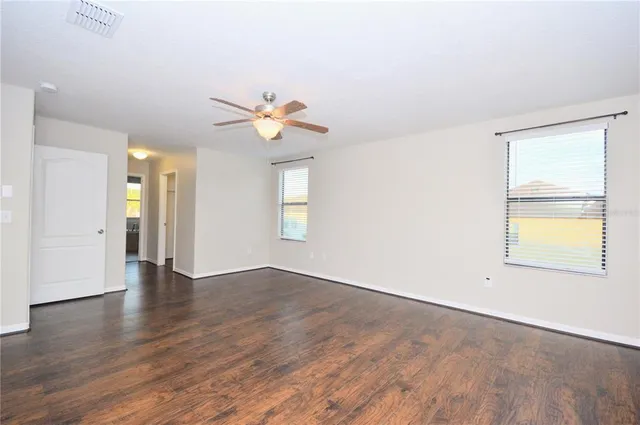 an empty room with wooden floor and window