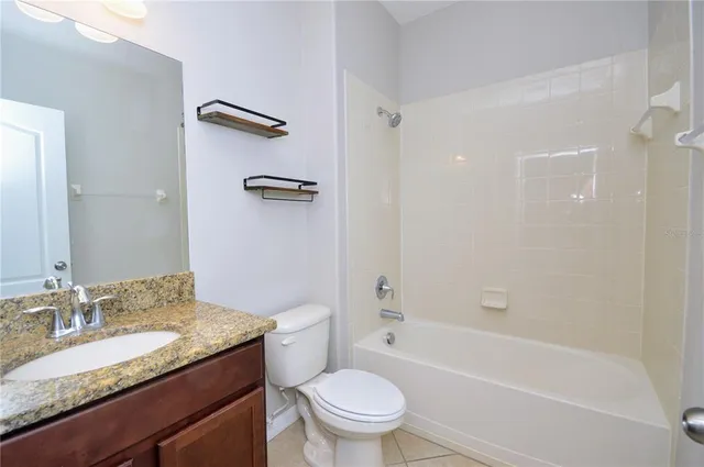 a bathroom with a granite countertop sink a toilet and a bathtub