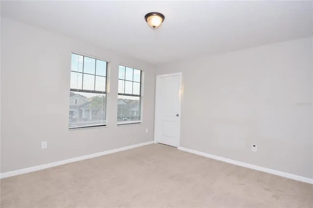 an empty room with windows and closet
