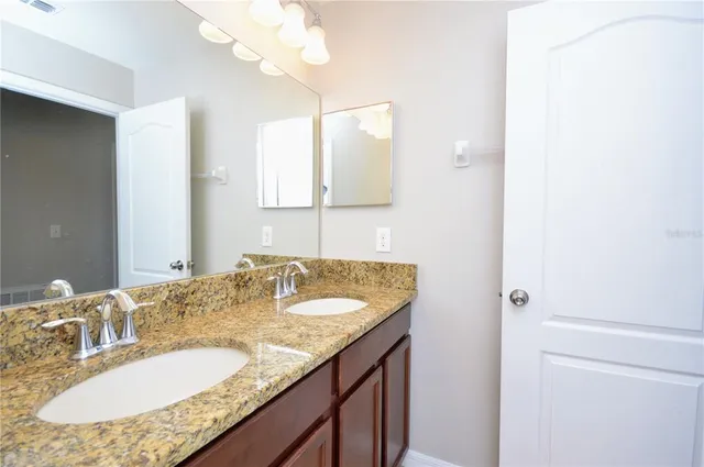a bathroom with a granite countertop sink and a mirror