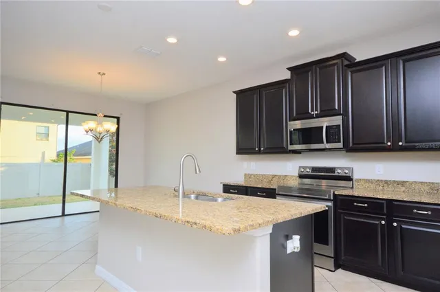 a kitchen with stainless steel appliances granite countertop a stove a sink and a microwave