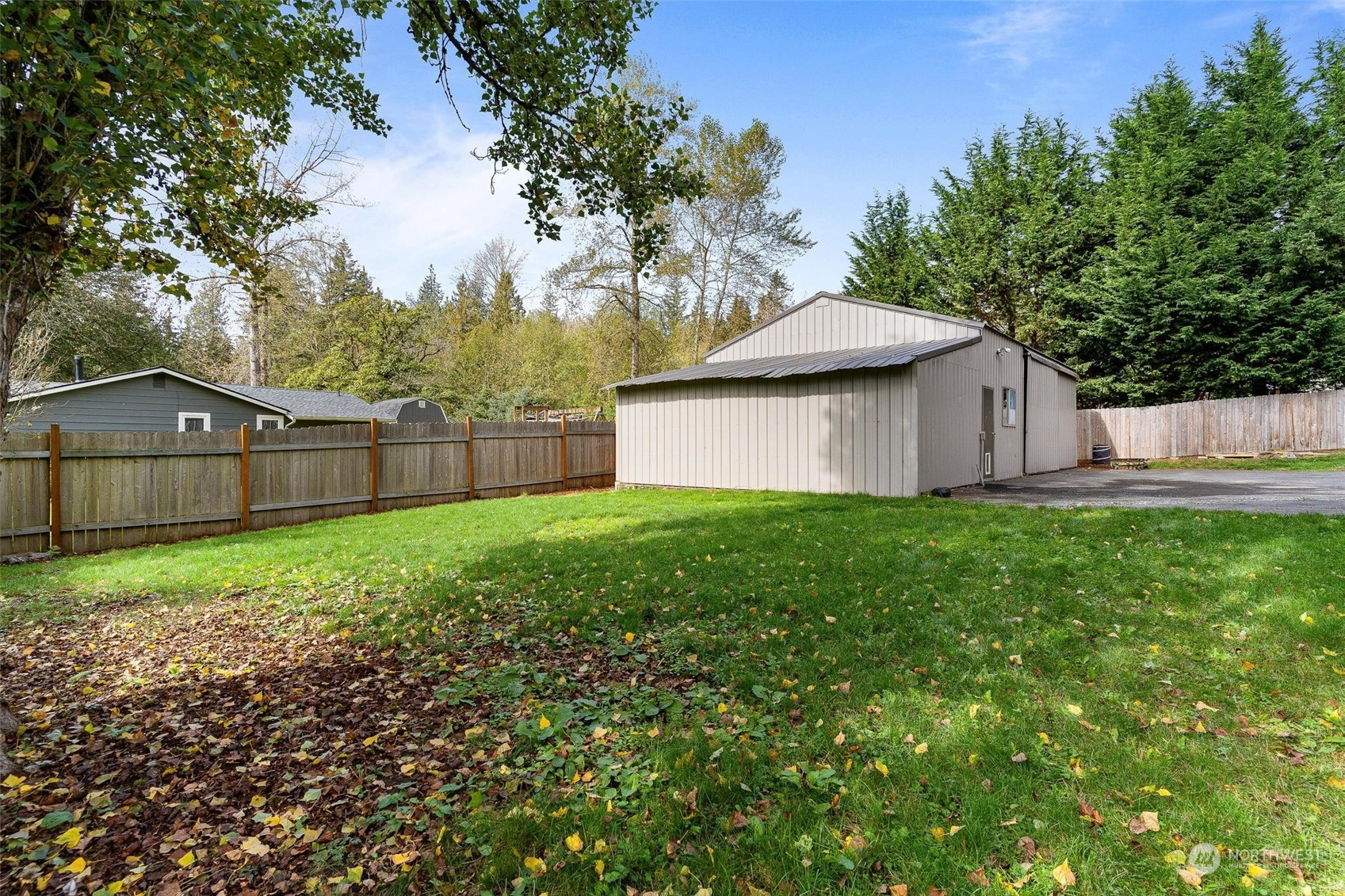 17821 Trombley Road Snohomish, WA 98290 - Photo 26 of 36 a view of a backyard with large trees and wooden fence