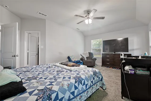 a bedroom with a large bed and a flat screen tv