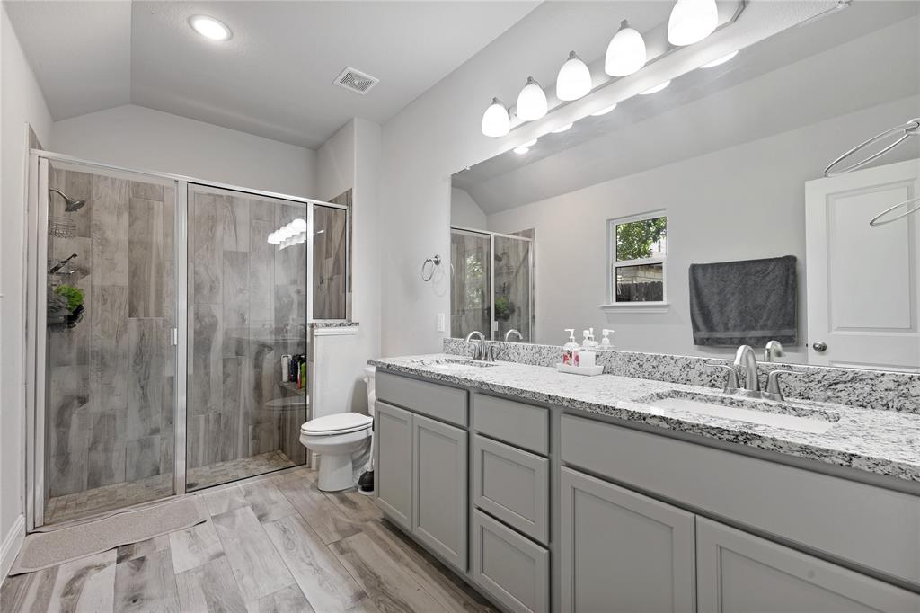 9221 White Settlement Road White Settlement, TX 76108 - Photo 22 of 30 a bathroom with double vanity sinks a toilet a shower a vanity and a mirror