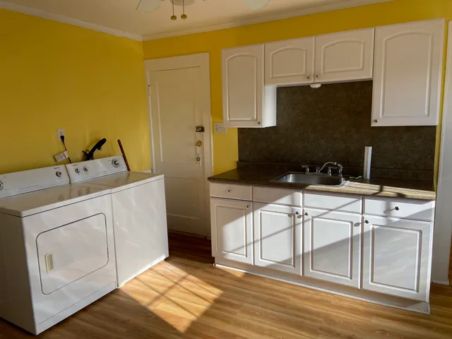 a view of a kitchen with white cabinets