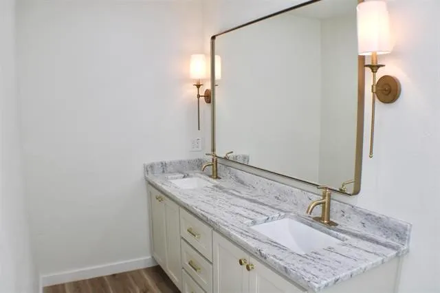 a bathroom with a granite countertop sink and a mirror