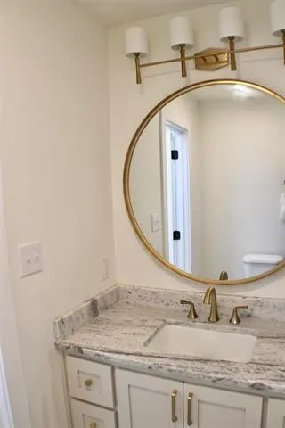 a bathroom with a granite countertop sink and a mirror