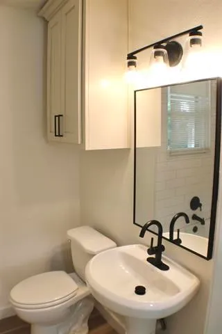 a bathroom with a sink mirror and toilet