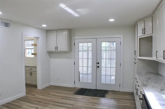 a view of entryway with kitchen and wooden floor
