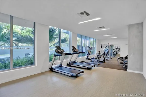a living room with gym equipment and floor to ceiling window