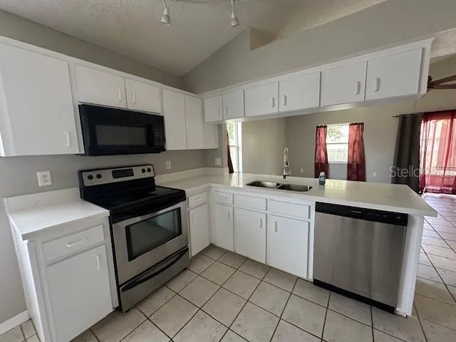 a kitchen with granite countertop appliances cabinets and a sink