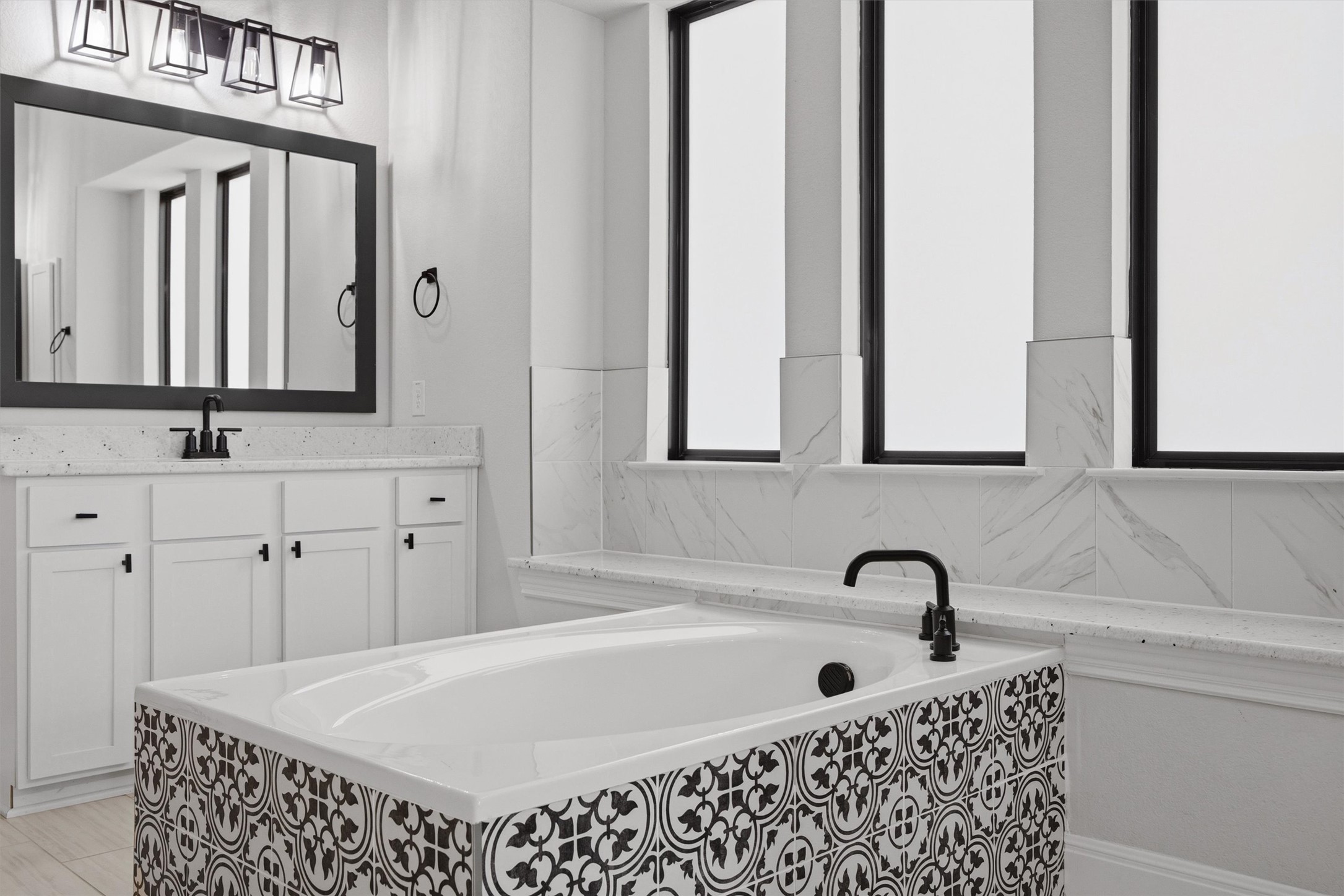 208 Tovas Secret Cove Georgetown, TX 78628 - Photo 17 of 40 a bathroom with a bathtub a sink a mirror and a window