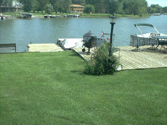 8 Lake Summerset Road Lake Summerset, IL 61019 - Photo 3 of 3 a view of a lake with lawn chairs and large trees