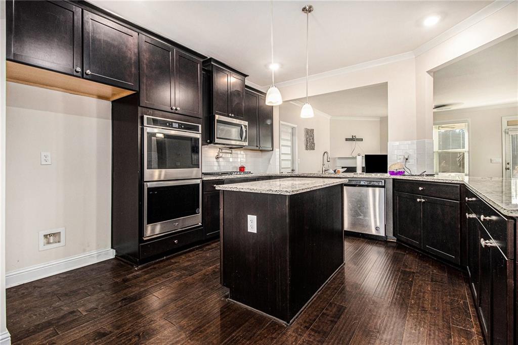 316 Conley Avenue Hampton, GA 30228 - Photo 7 of 27 a kitchen with stainless steel appliances granite countertop a stove a sink dishwasher a refrigerator and a oven with wooden floor