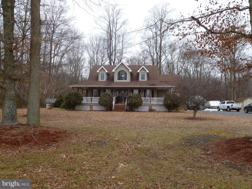 a front view of a house with a yard and trees