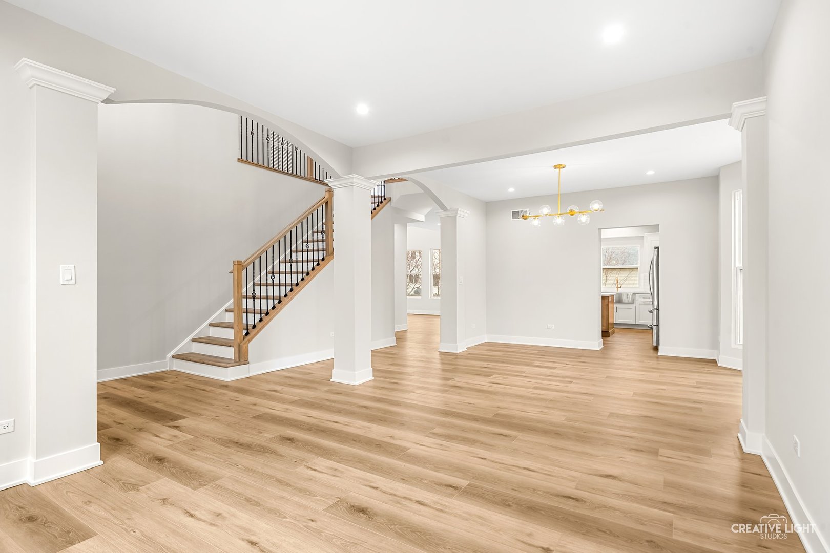 1472 Misty Lane Bolingbrook, IL 60490 - Photo 4 of 40 a view of an empty room with wooden floor and a kitchen view