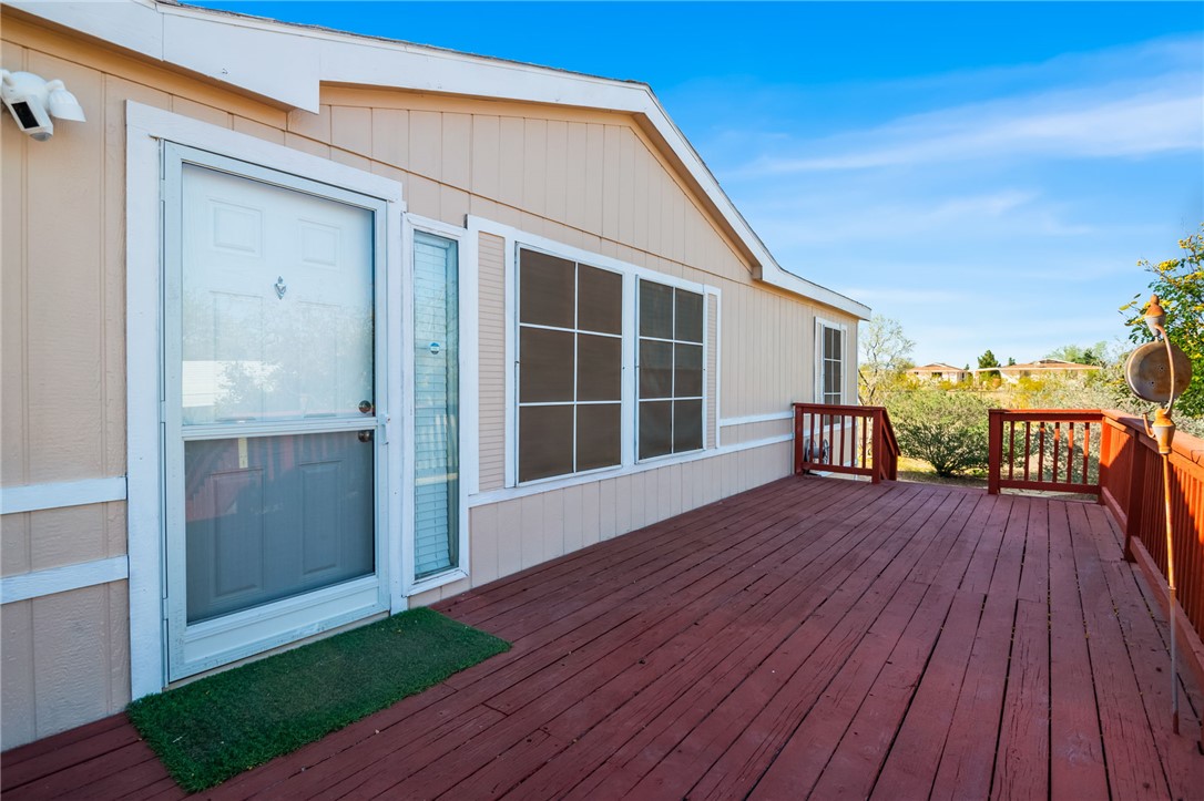 The property features a spacious outdoor deck with reddish-brown wood flooring and railings