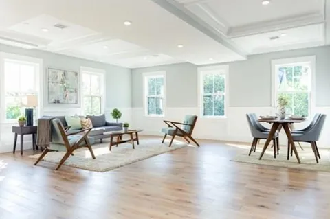 a living room with furniture wooden floor and windows