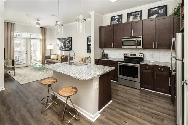 a kitchen with stainless steel appliances granite countertop a stove refrigerator and microwave