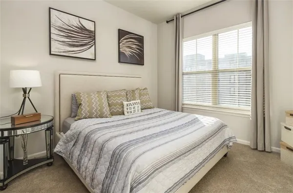 a bedroom with a bed and a painting on the wall