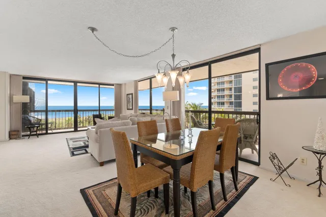 a dining room with furniture a chandelier and a rug