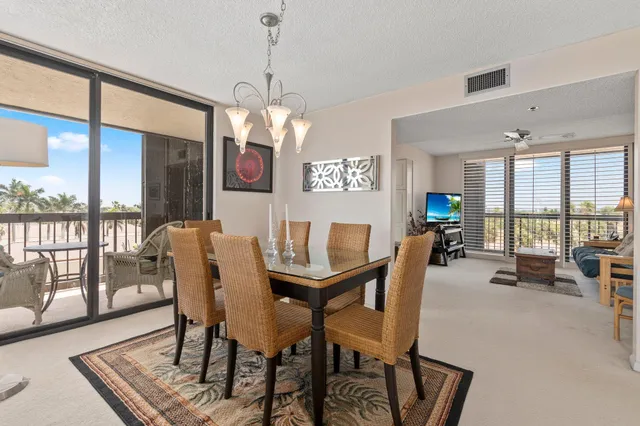 a view of a dining room and livingroom with furniture wooden floor a chandelier
