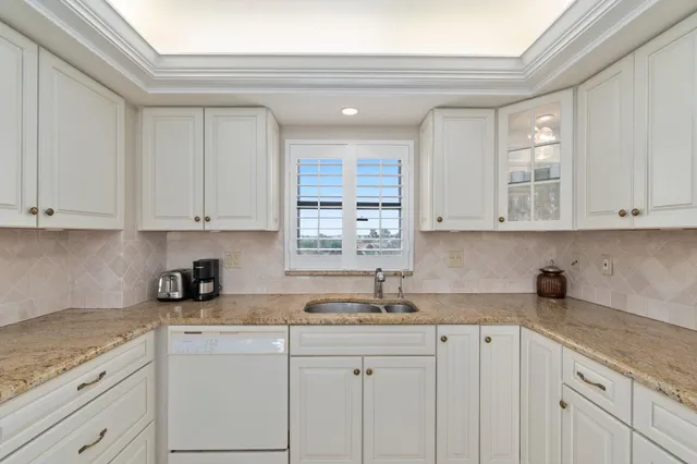 a kitchen with granite countertop white cabinets white appliances and a granite counter tops
