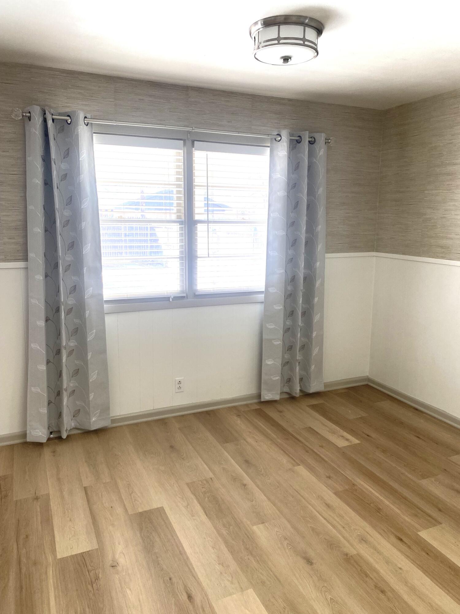 3415 58th Street Lubbock, TX 79413 - Photo 3 of 40 an empty room with wooden floor and windows