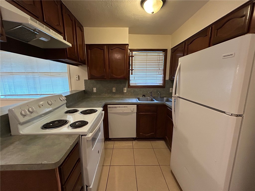 1913 Pine Tree Drive, Unit B Bryan, TX 77802 - Photo 4 of 13 a kitchen with a refrigerator sink stove and cabinets