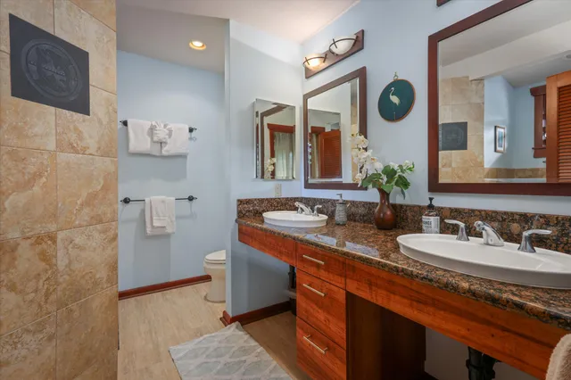 a bathroom with a double vanity sink mirror and bathtub
