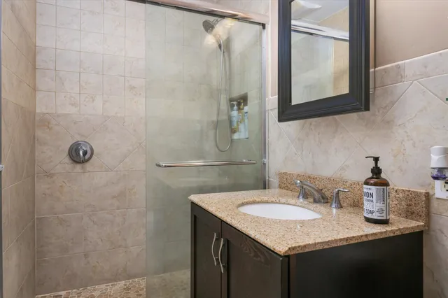 a bathroom with a granite countertop sink and mirror