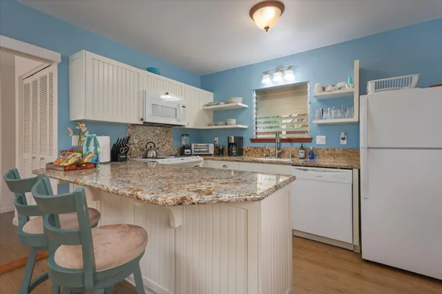 a kitchen with stainless steel appliances granite countertop a sink refrigerator and cabinets