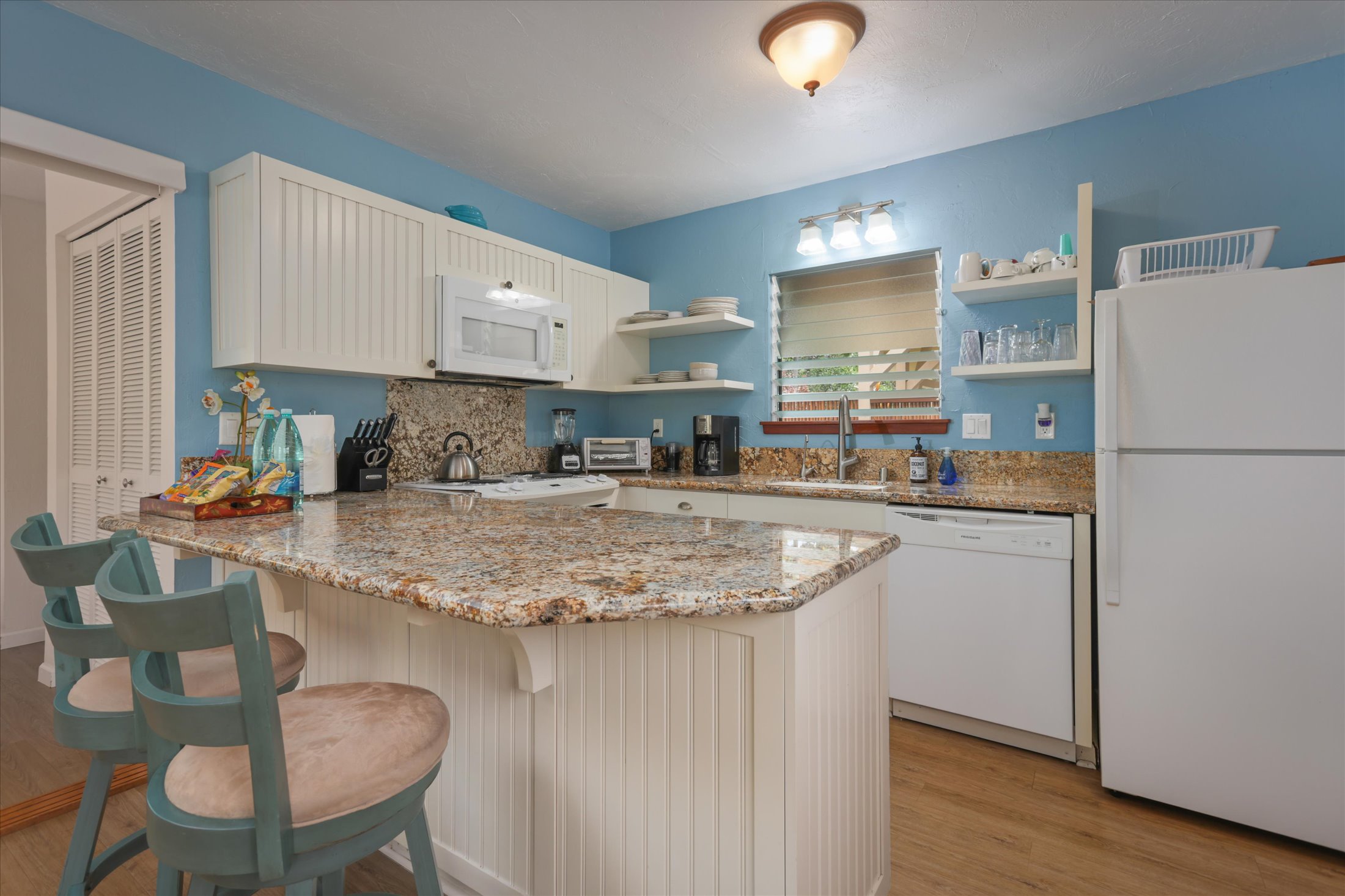 82-6289 Kahauloa Road Captain Cook, HI 96704 - Photo 24 of 29 a kitchen with stainless steel appliances granite countertop a sink refrigerator and cabinets