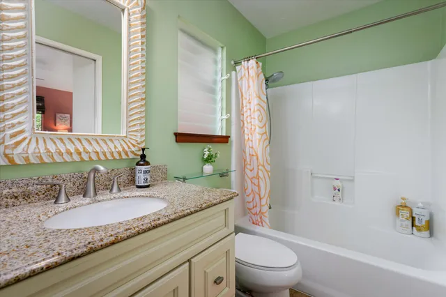 a bathroom with a granite countertop sink a toilet and a bathtub