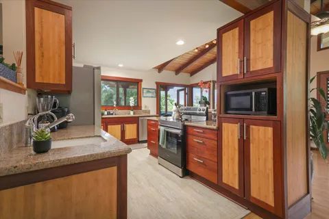 a kitchen with stainless steel appliances granite countertop a sink and a stove