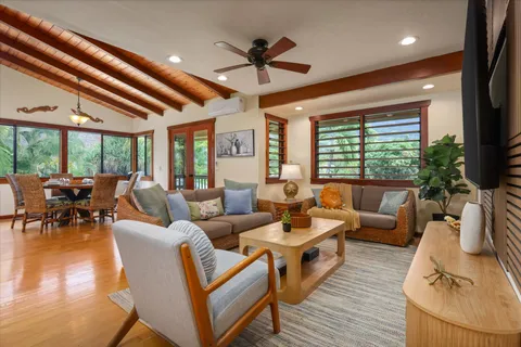 a living room with furniture a ceiling fan and a large window