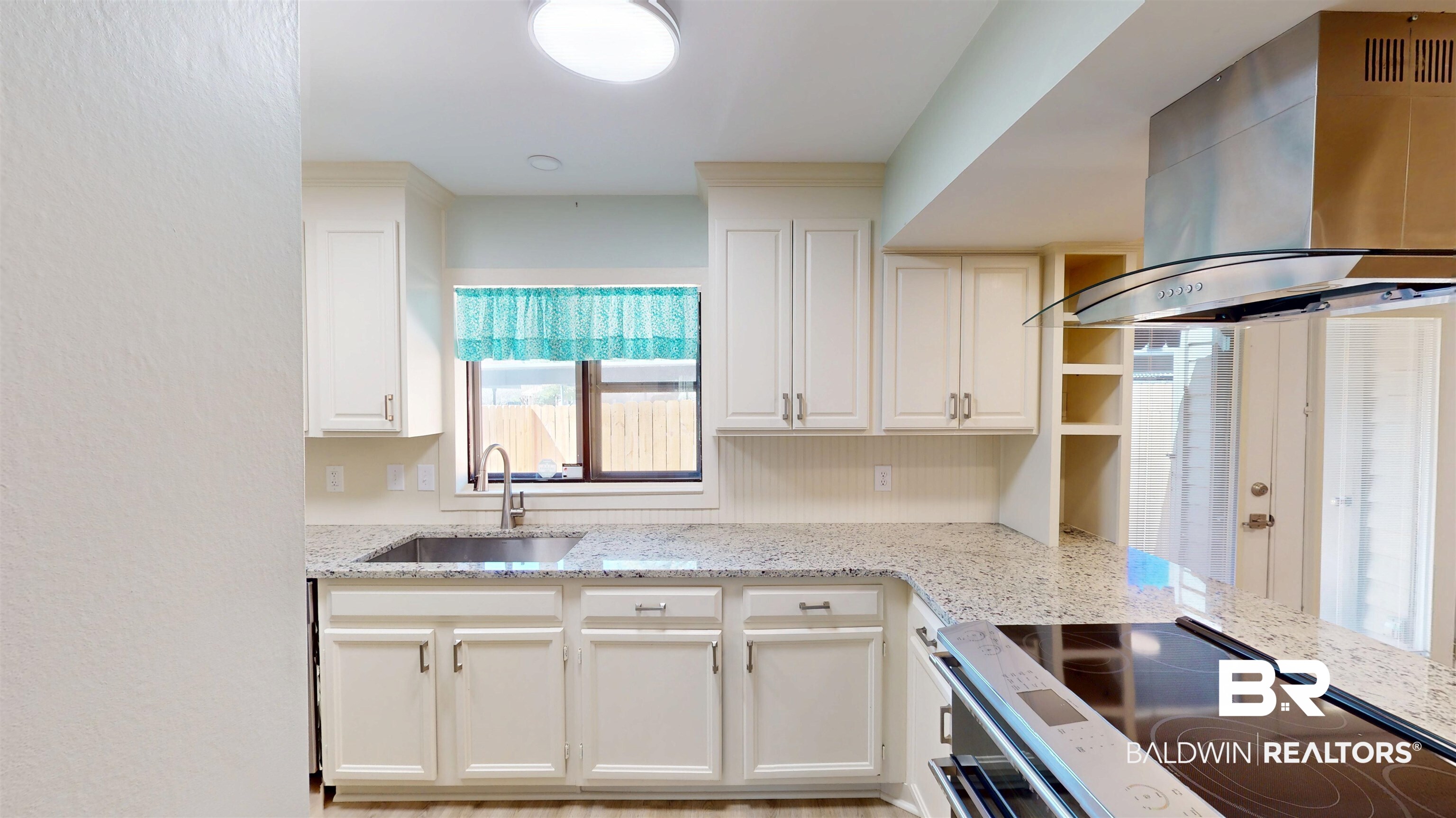 2901 Grant Street, Unit 902 Mobile, AL 36606 - Photo 5 of 35 Kitchen featuring island range hood, electric stove, light stone counters, white cabinets, and open shelves