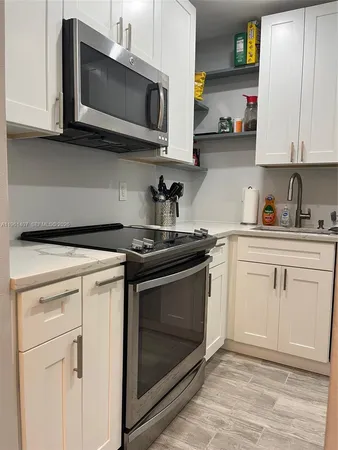 a kitchen with stainless steel appliances granite countertop white cabinets a sink and dishwasher