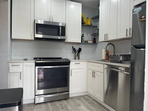 a kitchen with stainless steel appliances granite countertop a stove microwave and sink