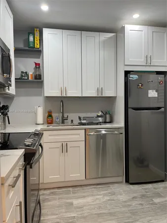 a kitchen with stainless steel appliances granite countertop a refrigerator sink and stove