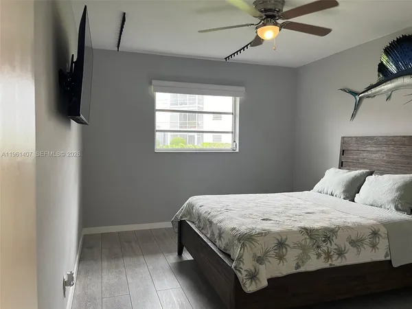 a bedroom with a bed and a flat tv screen on the dresser