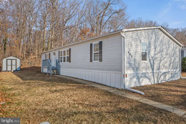 a view of a house with backyard and trees