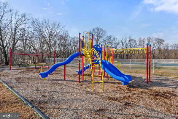 a view of a swimming pool with a yard and large trees