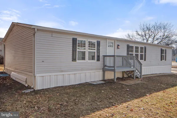a view of a house with backyard and wooden fence