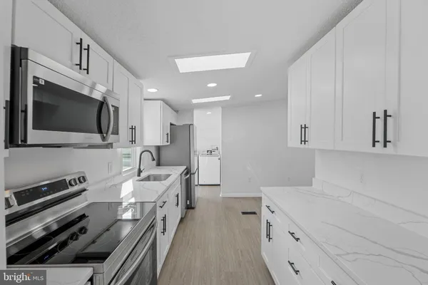 a large white kitchen with stainless steel appliances