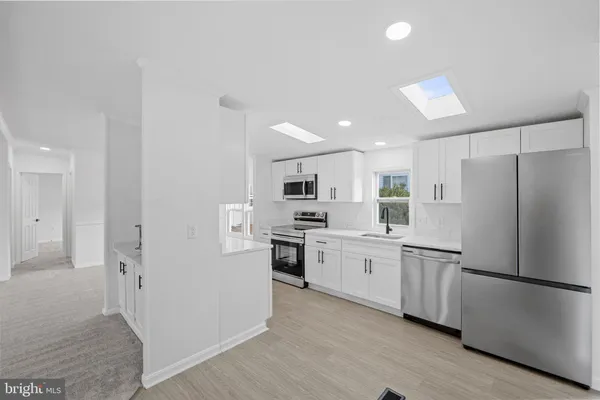 a kitchen with white cabinets and stainless steel appliances